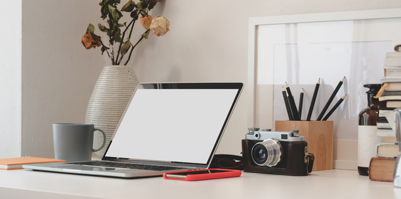 Desk with analog camera behind laptop